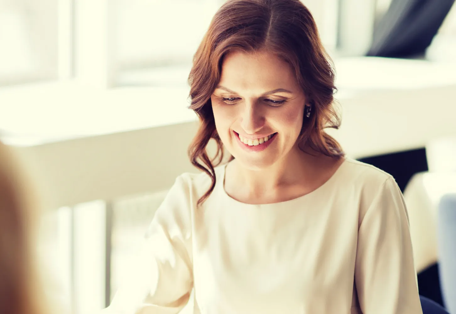 A woman smiling warmly during a conversation in a bright room