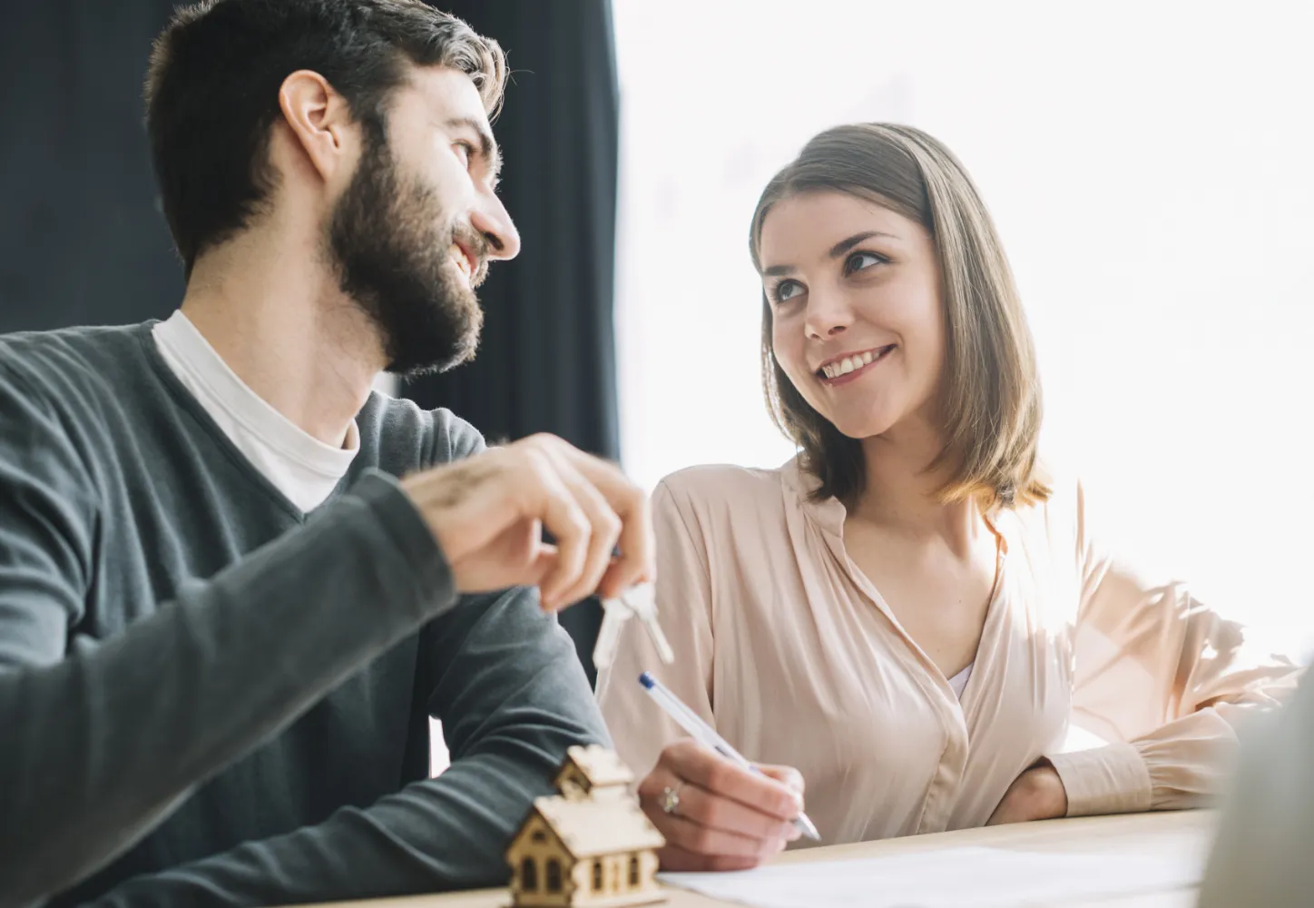A couple receiving keys across a desk